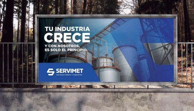 Cartel de SERVIMET en la vía pública con tanques industriales